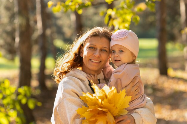 Mamá e hija en el parque en otoño