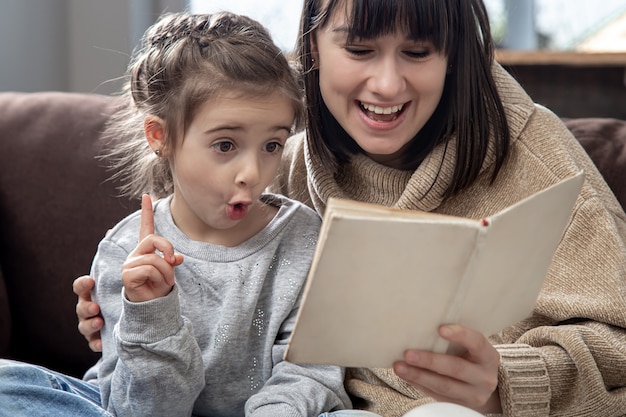 Mamá e hija pasan tiempo juntas leyendo un libro. El concepto de desarrollo infantil y tiempo de calidad.