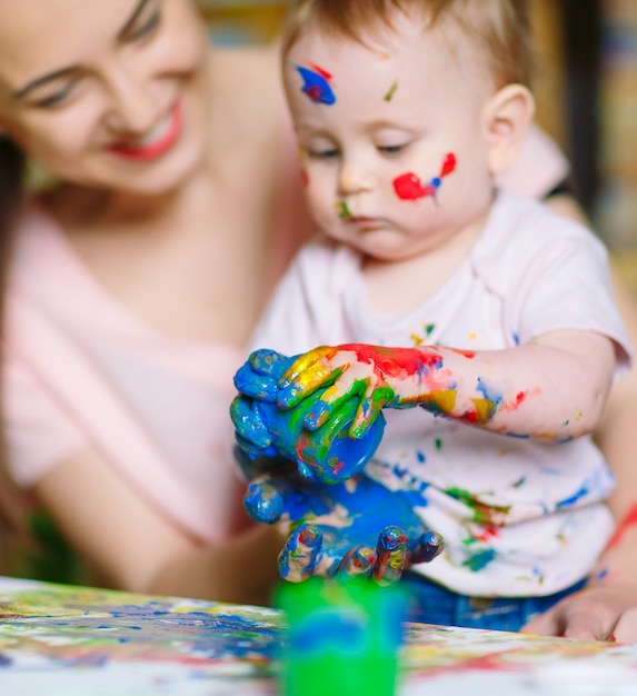 Mamá e hija pintan sobre lienzo en la escuela de dibujo