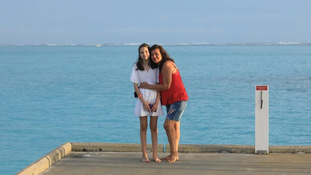 mamá e hija tomando fotos en el océano