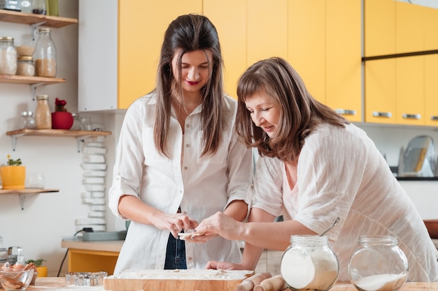 Mamá e hija trabajando juntos en la cocina