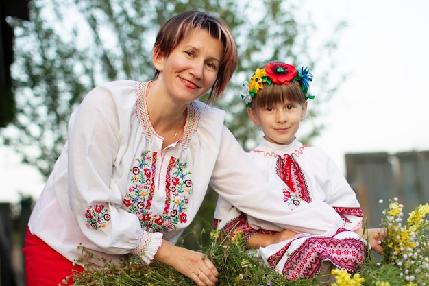 Mamá e hija vestidas con ropa nacional eslava. Mujeres ucranianas o bielorrusas con camisas bordadas.