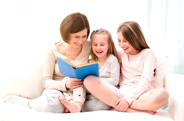 Mamá e hijas leyendo un libro infantil