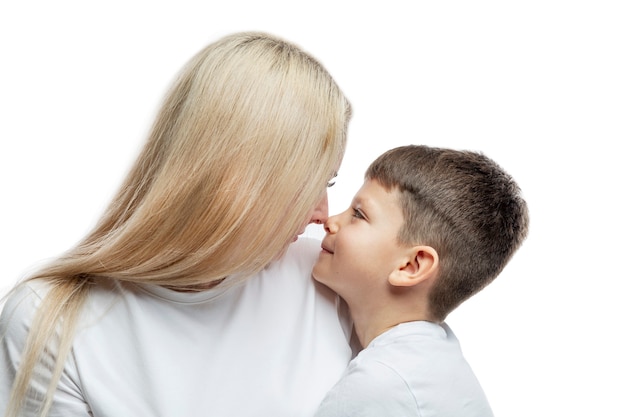 Mamá e hijo se abrazan tiernamente. Amor, comprensión y ternura. De cerca. Aislado sobre fondo blanco.