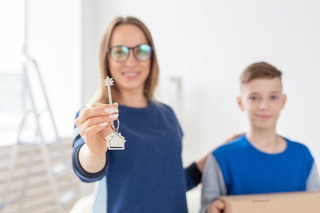 Mamá e hijo borrosos tienen las llaves del nuevo apartamento