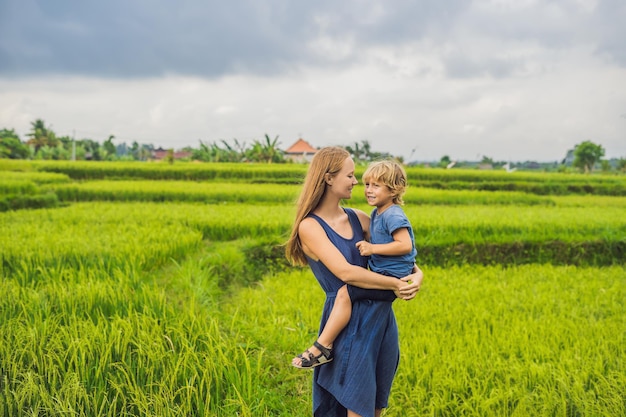 Mamá e hijo en el campo de arroz al fondo de las terrazas de arroz, Ubud, Bali, Indonesia. Concepto de viajar con niños. Enseñar a los niños en la práctica.