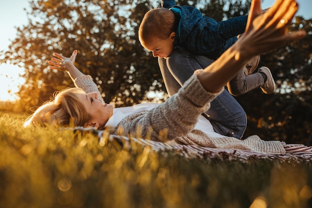 Mamá e hijo están jugando en el césped.