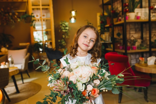 Mamá e hijo con flores en caffe. El hijo le da flores a la madre. familia linda. Día internacional de la mujer, 8 de marzo celebrando