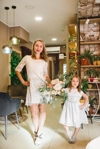 Mamá e hijo con flores en caffe. El hijo le da flores a la madre. familia linda. Día internacional de la mujer, 8 de marzo celebrando