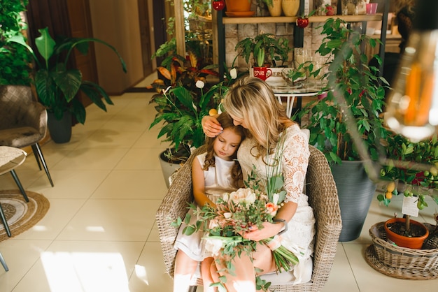 Mamá e hijo con flores en caffe. El hijo le da flores a la madre. familia linda. Día internacional de la mujer, 8 de marzo celebrando