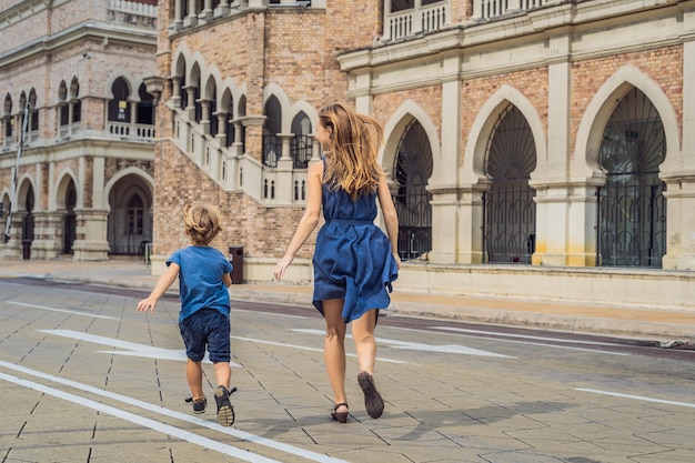 Mamá e hijo en el fondo del edificio Sultan Abdul Samad en Kuala Lumpur, Malasia. Concepto de viajar con niños