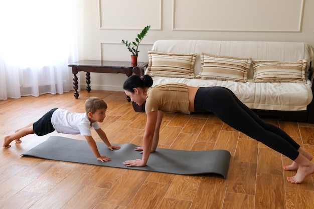 Mamá e hijo haciendo yoga en casa deportes en casa