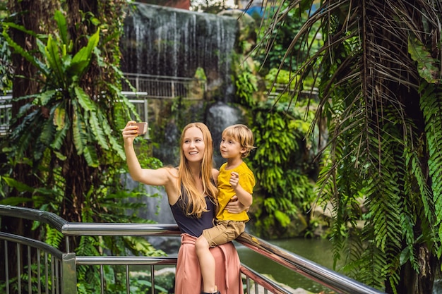 Mamá e hijo se toman una selfie al fondo de una cascada