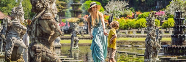 Mamá e hijo turistas en taman tirtagangga water palace parque acuático bali indonesia viajando con