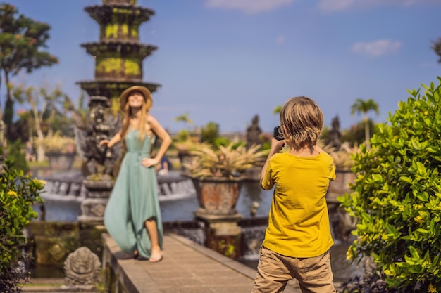 Mamá e hijo turistas en Taman Tirtagangga Water Palace Water Park Bali Indonesia Viajar con niños concepto Kids friendly place