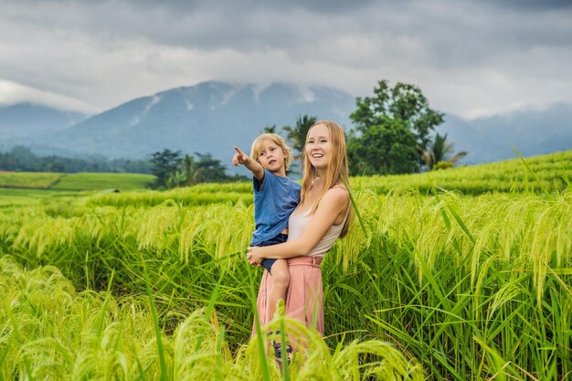 Mamá e hijo viajan en las hermosas terrazas de arroz de Jatiluwih con el telón de fondo de los famosos volcanes en Bali, Indonesia Viajar con el concepto de niños