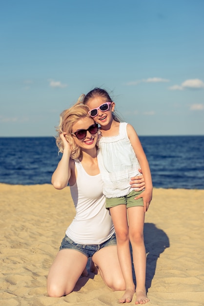 Mamã e sua filha pequena bonito em vidros de sol.