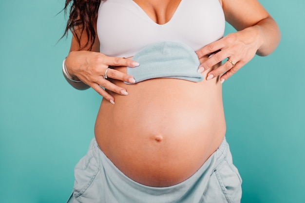 Mamá embarazada prepara la ropa para el bebé.