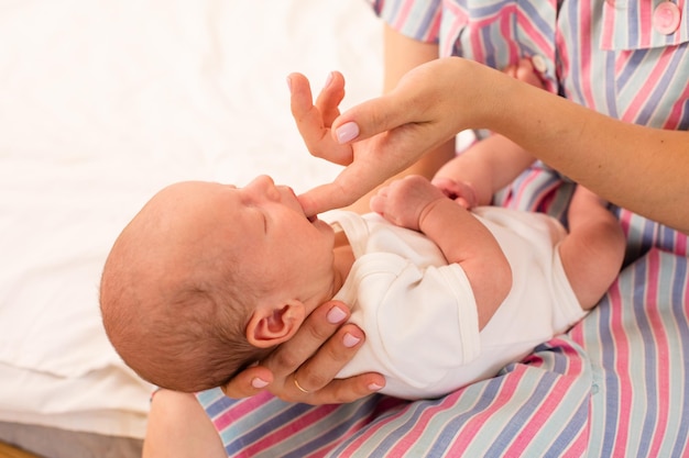 Mamá le enseña a su bebé recién nacido el reflejo de succión