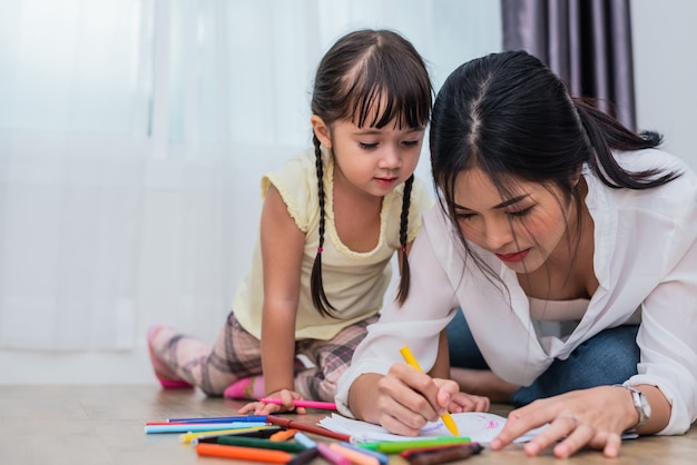 Mamá enseñando a su hija a dibujar en la clase de arte. Regreso a la escuela y al concepto de educación.