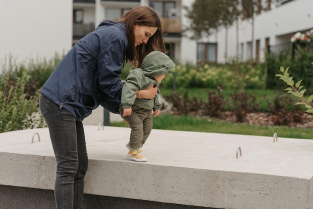 Una mamá le está enseñando a su niña pequeña cómo hacer pasos en la calle al mediodía