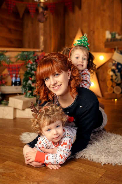 Mamá feliz pasa tiempo con sus hijos celebrando la Navidad.