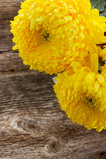 Mamá flores amarillas frescas en la mesa de madera