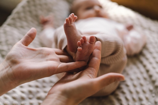 Mamá haciendo masaje al bebé mamá masajeando al bebé con los pies descalzos masaje preventivo para el recién nacido