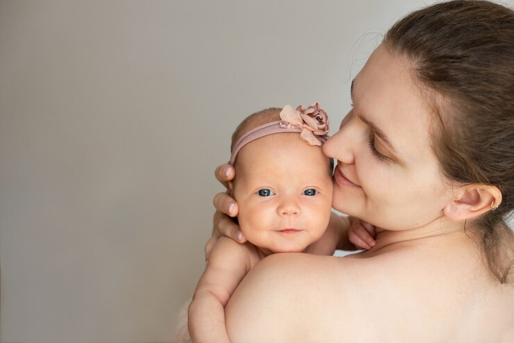 Mama hält die Hand eines Neugeborenen.
