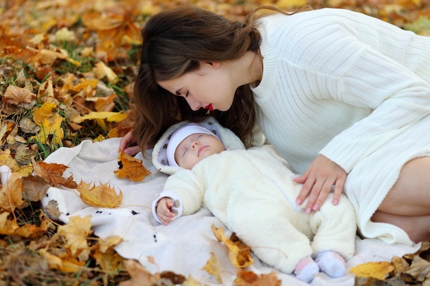 Mama hält kleine Tochter im Herbstwald