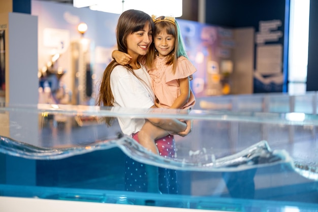 Mamá con hija pequeña visita un museo de ciencias