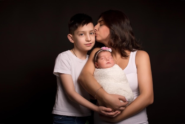 Mamá hijo e hija en un fondo negro