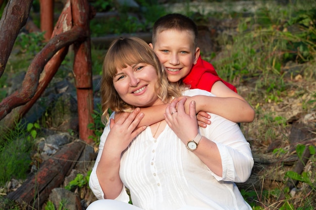 Foto mamá y hijo felices en una caminata de verano riéndose y mirando a la cámara