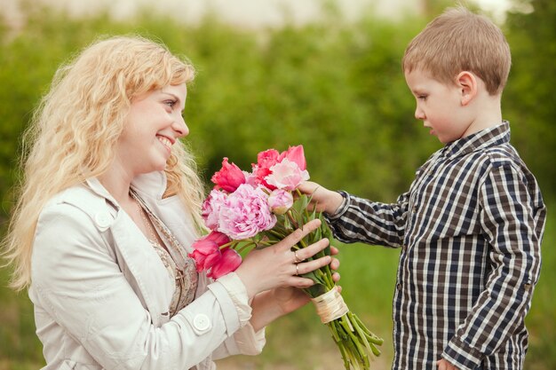 Mamá con hijo y flores para el día de la madre.