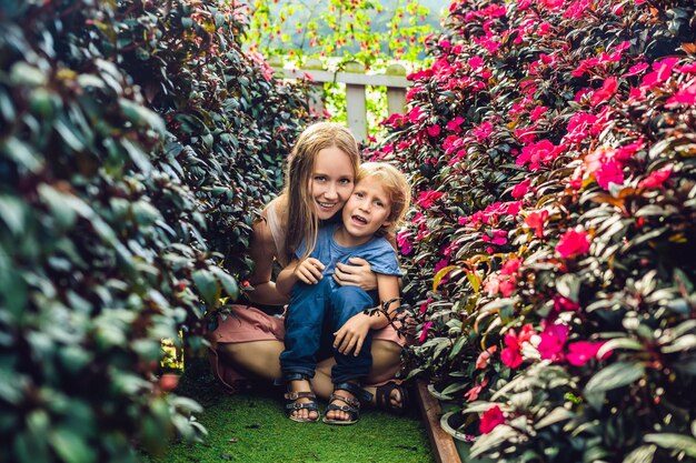 Mamá y el hijo de un invernadero de flores.