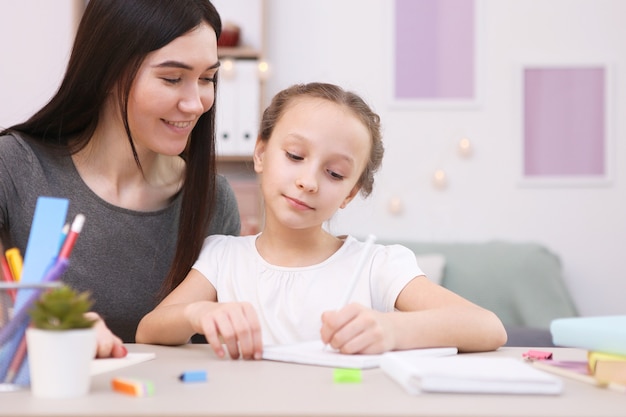 Mama hilft dem Mädchen bei den Hausaufgaben Kinder und Eltern