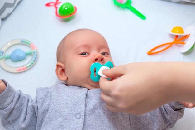 mamá intenta darle un chupete a un bebé que llora. enfoque selectivo