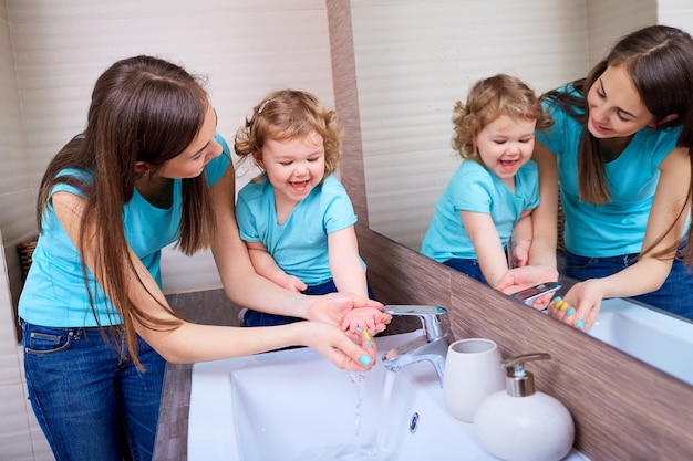 Foto mamá lavando las manos del bebé