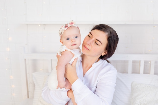 Mamá mira ansiosamente a la niña en la cama en casa, amor y cuidado materno