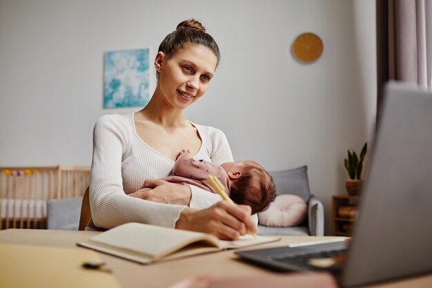 Mamá multitarea que sostiene a su recién nacido