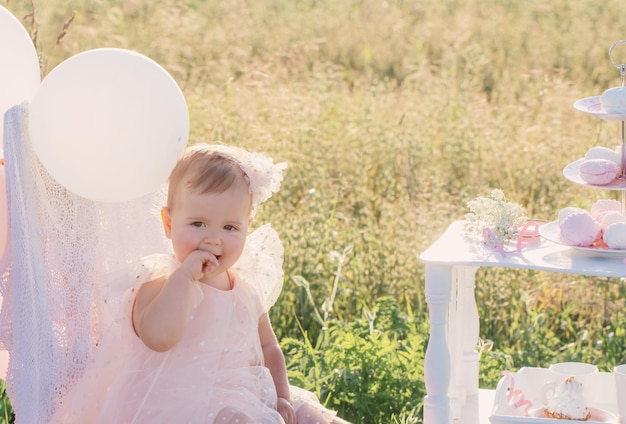 Mamá y niña con pastel de cumpleaños en un día soleado