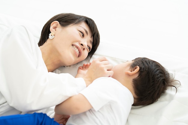 Mamá y niño acostados y jugando adentro