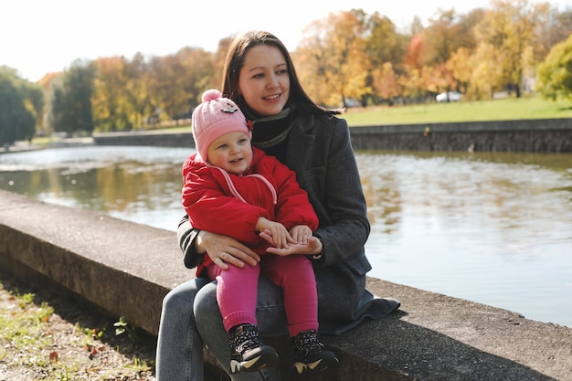 mamá y niño divirtiéndose y caminando en el parque de otoño.