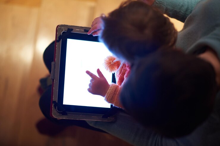 Foto mamá y niño usando una tableta para navegar por internet y fotos en la vista superior de casa