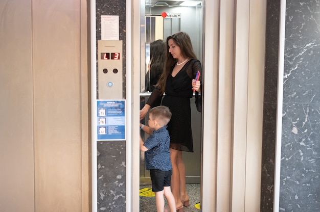 Foto mamá y niño viajan en el ascensor.