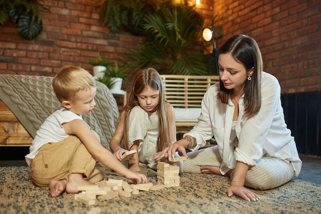 Mamá y niños juegan en casa.