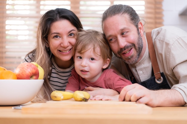 Mamá y papá en la cocina de la casa con sus hijos pequeños Pasan un buen rato preparando la cena juntos