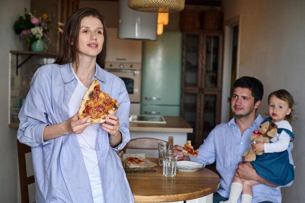 Mamá papá e hija comen juntos en la cocina Familia feliz