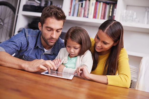 Foto mamá, papá e hijo en casa con tableta para enseñar, aprender y apoyar en la educación con amor aplicación digital de aprendizaje electrónico y padres con niña para ayudar en el crecimiento y desarrollo de la escuela en casa en línea