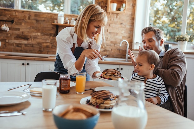 Mamá y papá con su hijo desayunando